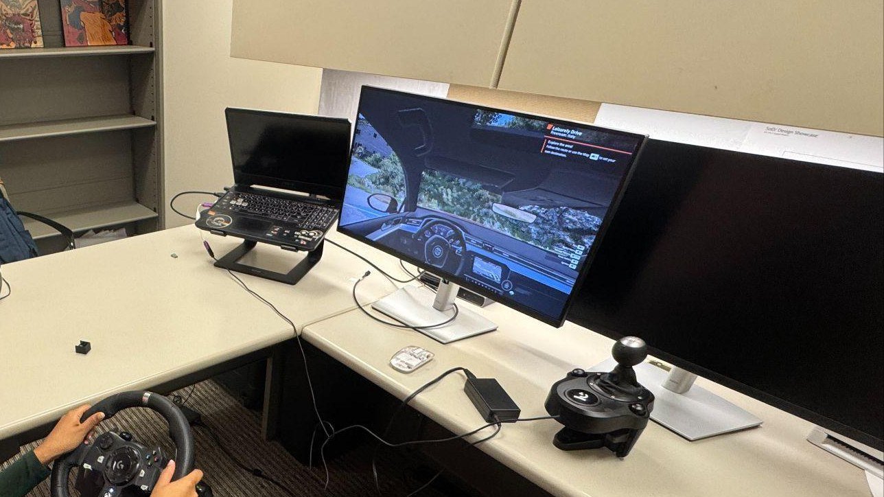DrivAR simulator lab setup with monitor, steering wheel, laptop, and controls